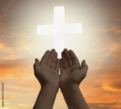 Religion. Christian man praying against sky with glowing cross, closeup