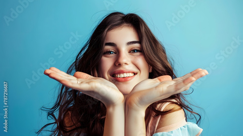 Portrait of attractive cheerful brownhaired girl holding on palms copy space ad isolated over bright blue color background : Generative AI photo