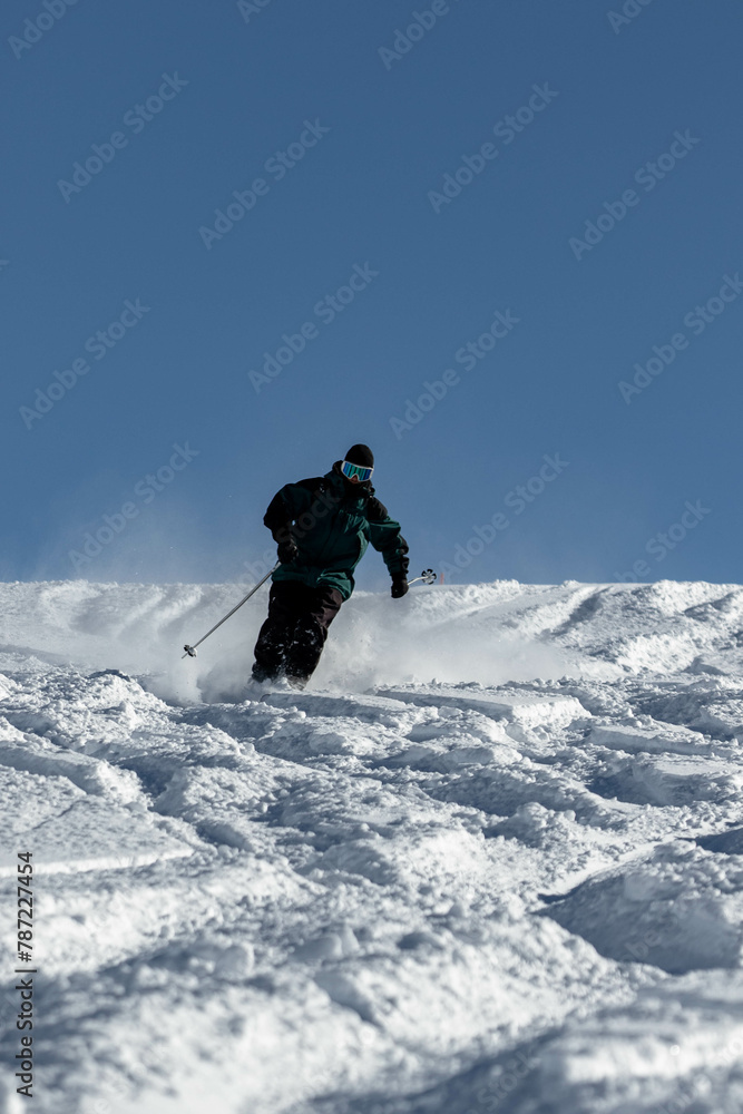 Skier skiing in the Swiss alps off-piste in white snow