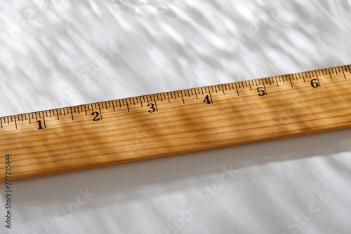 Close-up of wooden ruler on white background in sunlight