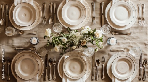 A dining table is elegantly set with white plates, silverware, and glassware, creating a sophisticated and inviting ambiance