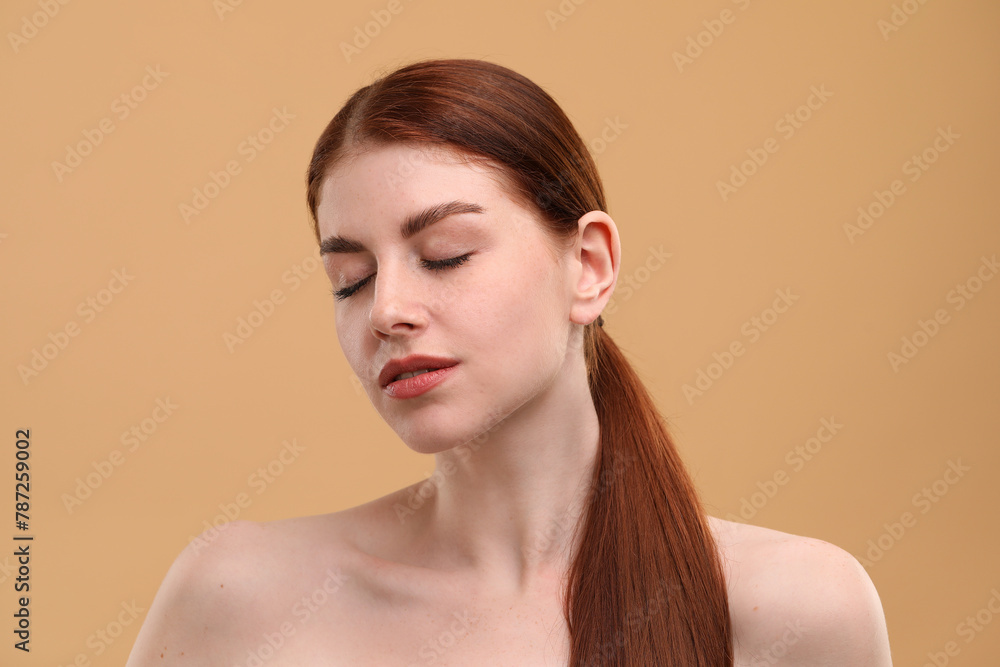 Fototapeta premium Portrait of beautiful woman with freckles on beige background