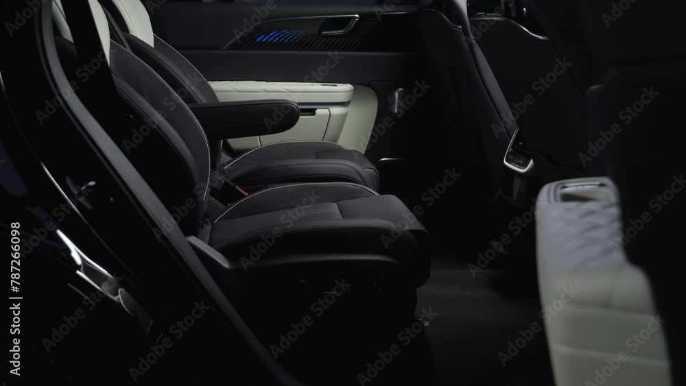 The camera slowly moves around the black interior of a premium car. View of the rear seats The camera slowly moves around the black interior of a premium car. View of the rear seats
