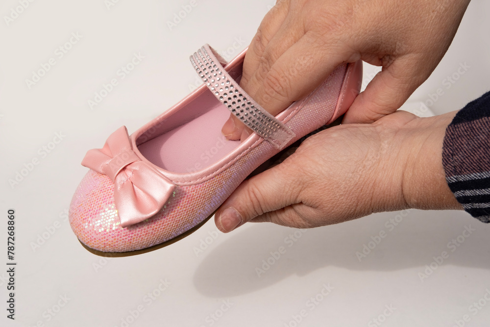 Beautiful fancy pink princess shoes with bows and glitter for little princess in female hands, buying new shoes, happy childhood, Stylish pink outfit for party