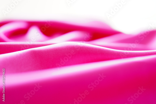 Pink silk or satin background, wavy, elegant and elegant. Close-up, background. Space for designblur or blurry photo