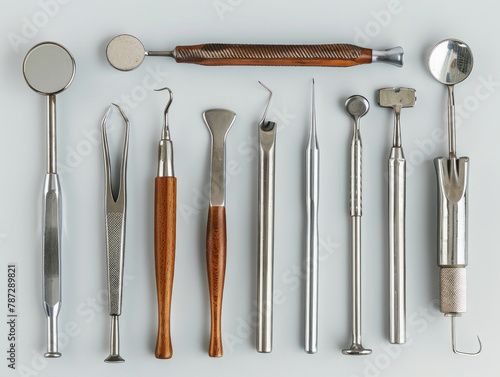Collezione di vari strumenti dentali in acciaio inossidabile disposti in modo professionale su una superficie bianca photo