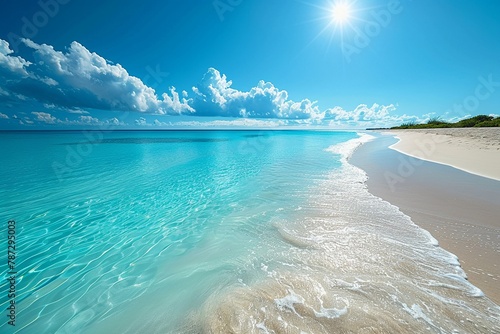 Wideangle view of a calm, turquoise sea meeting a white sandy beach under a sunny sky, embodying paradise