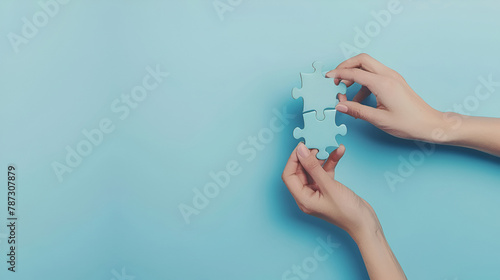 Young adult woman hand fingers holding and connecting different two white puzzle pieces on light blue table background. Pastel color. Closeup. Compatibility concept. Point of view shot.