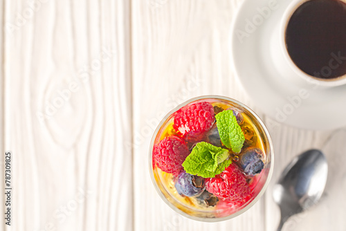 Healthy vanilla chia pudding in a glass with fresh berries and coffee