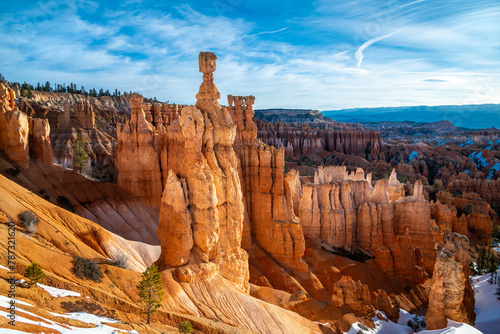Tall hoodoo rock needle called „Thors hammer“ in Bryce Canyon National Park (Utah, USA) on a sunny winter morning with melting snow and bright blue sky. Famous beige-reddish sandstone formation.