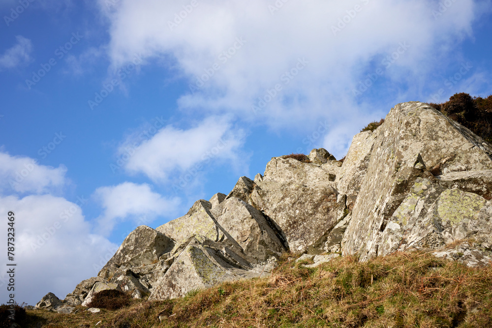 A rocky outcrop against a  blue sky with white clouds at Craignish Point. Ardfern, Argyll and Bute, Scotland