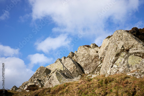 A rocky outcrop against a  blue sky with white clouds at Craignish Point. Ardfern, Argyll and Bute, Scotland photo