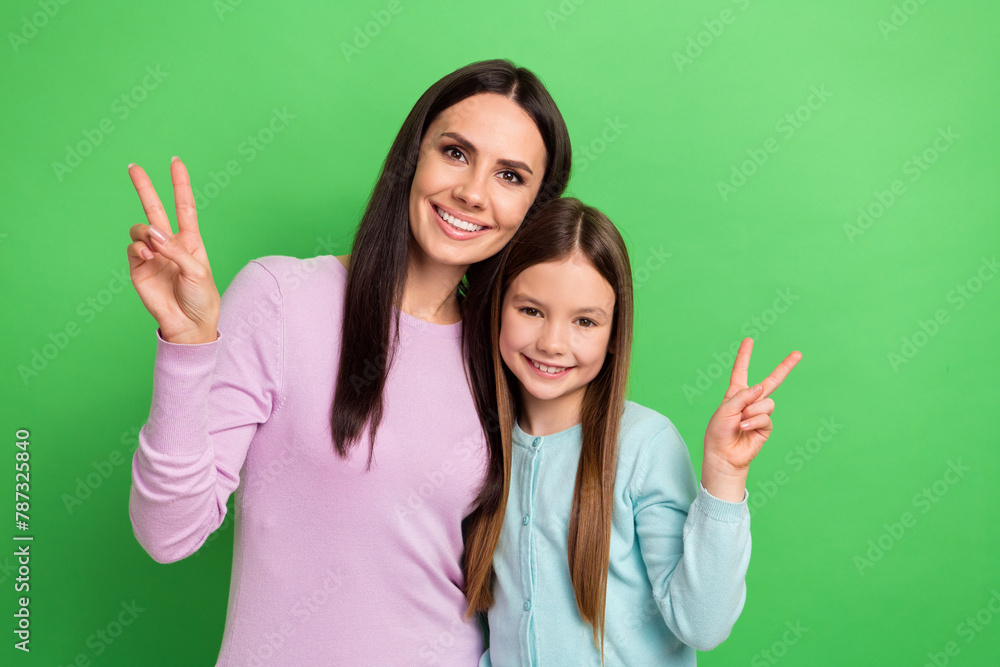 Portrait of two people mother daughter toothy smile show v-sign isolated on bright green color background - obrazy, fototapety, plakaty 