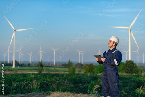 engineers working and holding the report at wind turbine farm Power Generator Station on mountain,Thailand people,Technician man and woman discuss about work