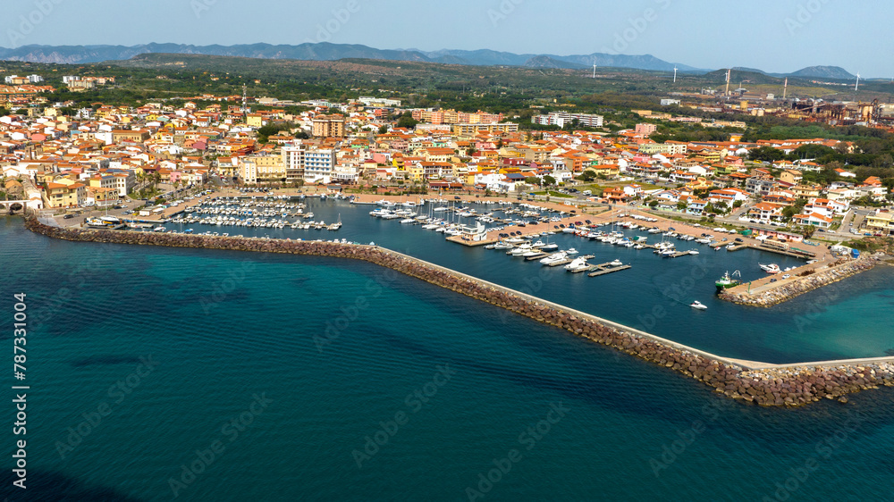 Aerial view of Portoscuso, an Italian municipality in the province of Southern Sardinia, Italy. The town, built on the sea, also has a small port that is very active in the summer season.