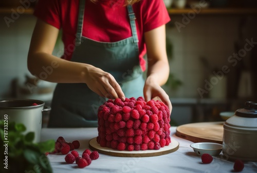 woman preparing homemade raspberries on a cake