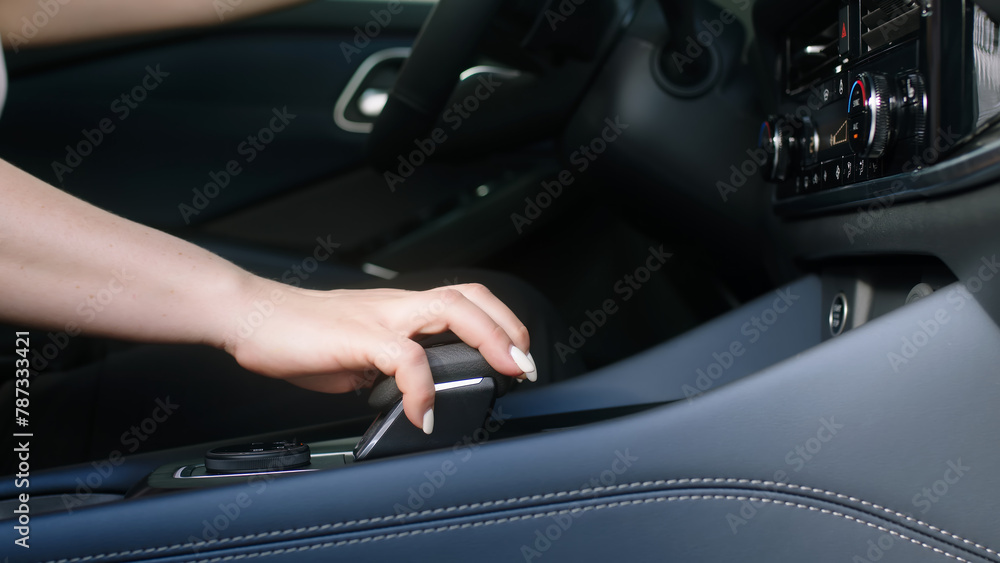 Business woman in her new modern car presses the start button. A middle-aged woman is happy to buy a new car. The concept of modern automotive technologies.