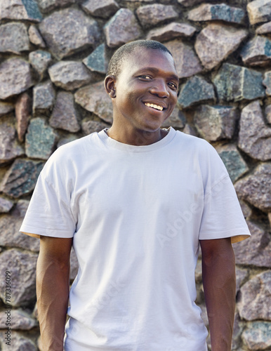 smiling young african man with casual clothing, stone background