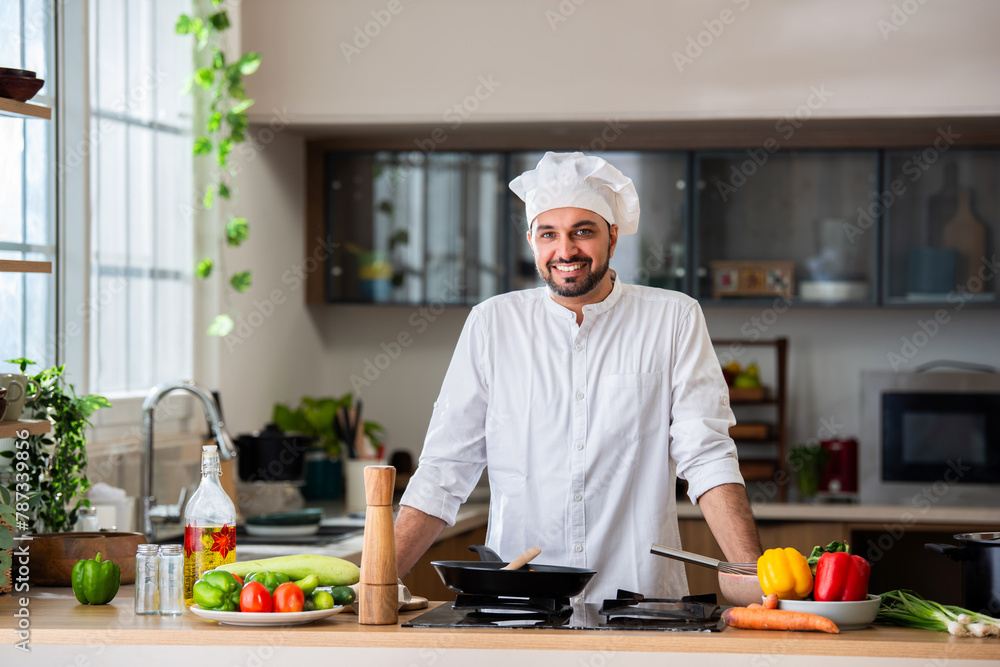 confident asian indian male young chef portrait in kitchen confident asian indian male young chef portrait in kitchen