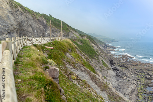 mountain trail enclosed by a wooden fence next to the Atlantic Ocean.