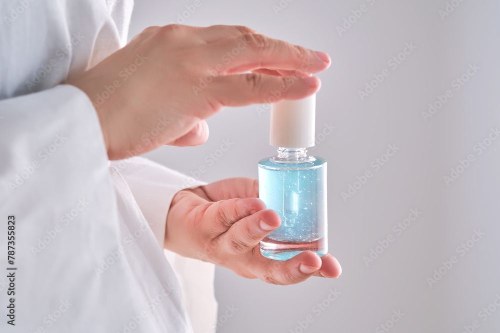 Blue serum with pipette in a womans hands in a robe. Blue serum with pipette in a womans hands in a robe.