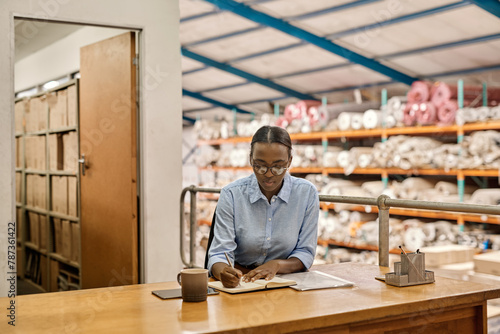 Young African woman working at her desk in a warehouse