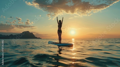 A portrait of the woman gazing at the horizon while practicing a mountain pose on the paddleboard, feeling grounded and present.  photo