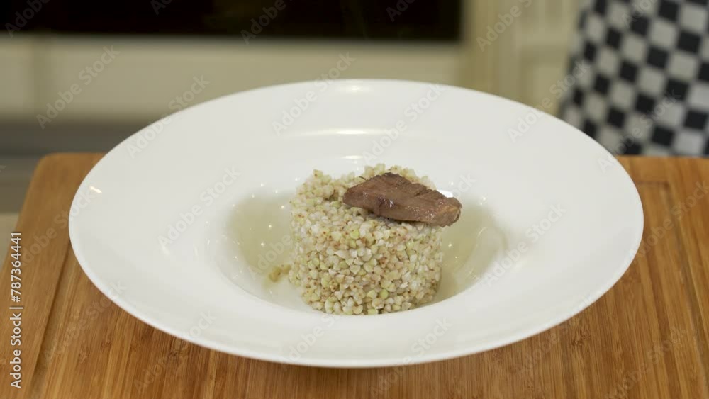 Serving buckwheat porridge with fried slices of neat's tongue