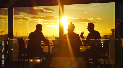 Silhouette of business people drinking wine in a restaurant at sunset © korkut82