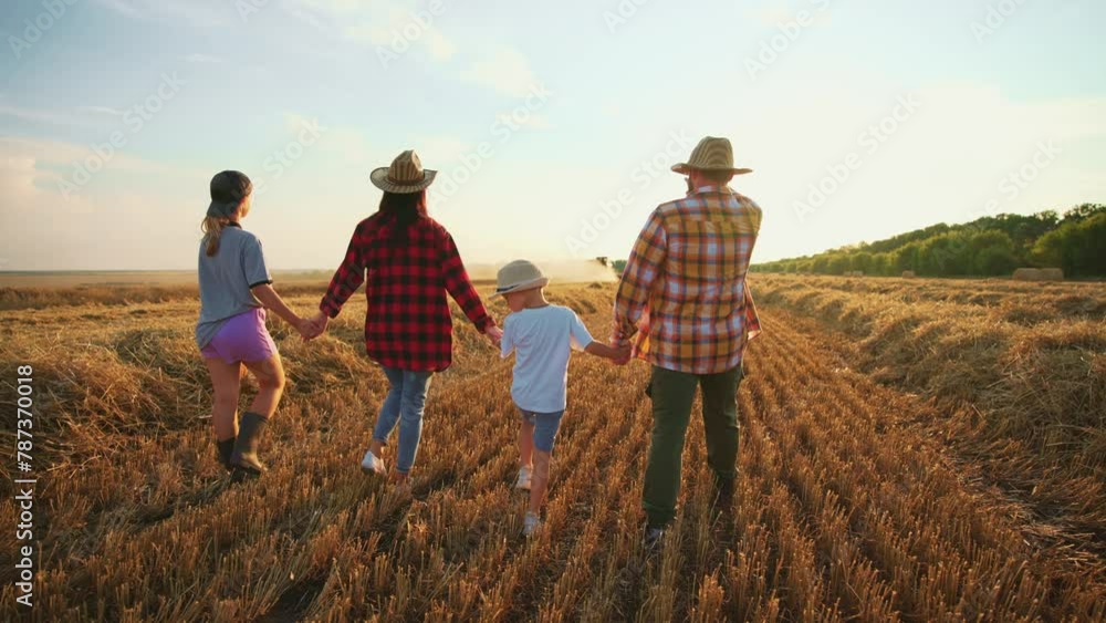 Family walking on wheat field at sunset. Happy parents children holding hands talking together in summer vacations. Farmers having fun together on farm. Farming joyful, parenthood, leisure concept. Family walking on wheat field at sunset. Happy parents children holding hands talking together in summer vacations. Farmers having fun together on farm. Farming joyful, parenthood, leisure concept.