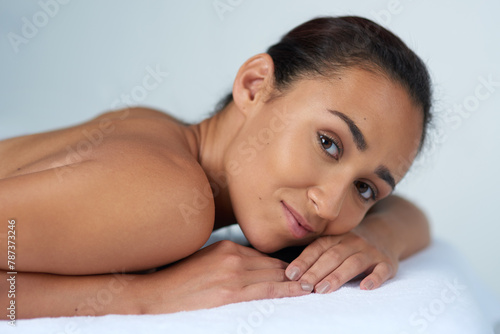 Spa, massage and portrait of woman on bed with smile for vacation, treatment and body care in luxury hotel. Female person, happy and relax at resort for wellness, pamper and stress relief on holiday