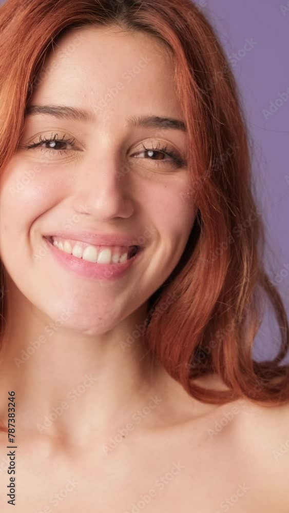 Close-up of smiling girl looking at camera on purple background