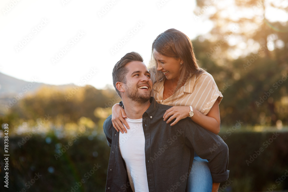 Fototapeta premium Happy couple, hug and piggyback with love in nature for bonding, holiday or outdoor weekend together. Young man carrying woman with smile for embrace, journey or adventure outside in countryside