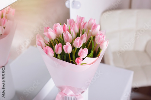 Bouquet of beautiful pink tulips flowers in vase on table