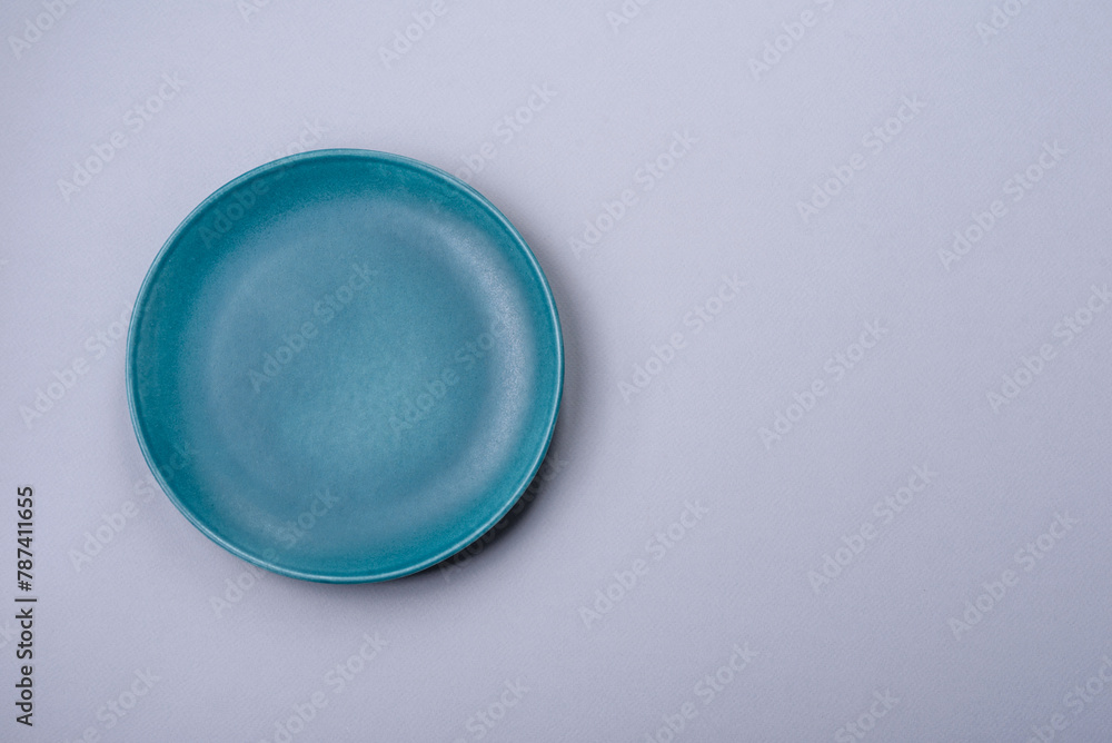 An empty plate on a gray concrete background with copy space An empty plate on a gray concrete background with copy space