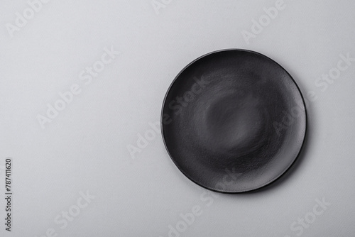 An empty plate on a gray concrete background with copy space