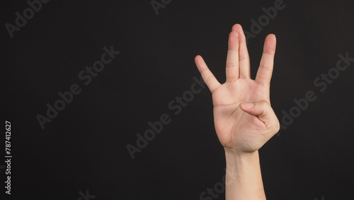 Hip-hop west coast hand sign on black background. photo