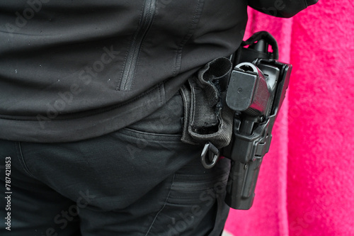 A gun on a policeman's belt. Pistol in the holster of a member of the special police forces. Weapon of police officer. 