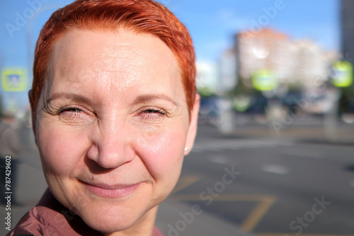 The close-up picture shows a girl with bright red hair. Red hair stands out from the general background, drawing attention to the unique appearance of a person.