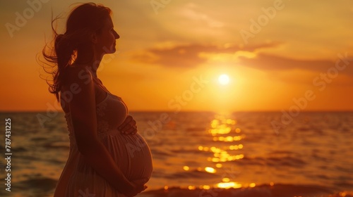 Portrait of a young pregnant woman at sunset by the sea.