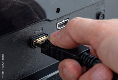 Close-up of a hand plugging a DisplayPort cable into the connector DP-IN. Insert the DisplayPort cable