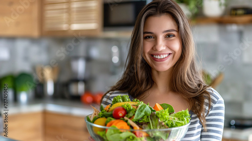 Radiant Young Woman Presenting a Fresh Organic Salad in Modern Kitchen