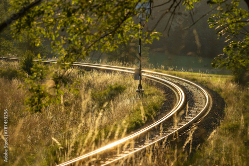 a railway track shining in the rays of the setting sun