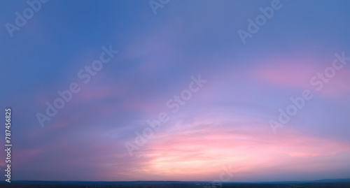 Ideal for Sky replacement project  Large Panoramic  pastel pink-orange-blue evening sky after sunset with soft clouds illuminated by orange sunset  aerial photography  far horizon without obstacles.