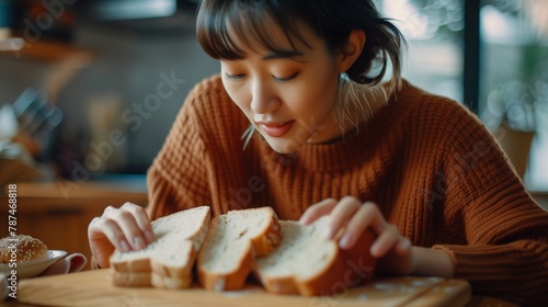 asian young woman hand push out, refusing to eat white bread slice on chopping board in food meal at home, girl having a stomach ache.  photo