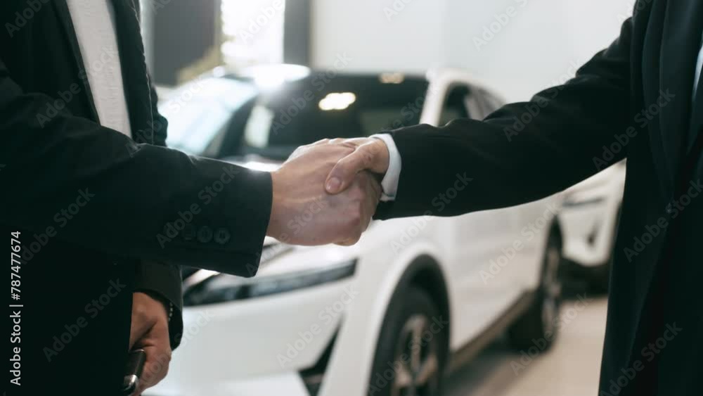 Electric car buying concept. A manager makes a deal in a modern electric car dealership with a client. Happy buyer enjoying his new purchase. Electric car buying concept. A manager makes a deal in a modern electric car dealership with a client. Happy buyer enjoying his new purchase.