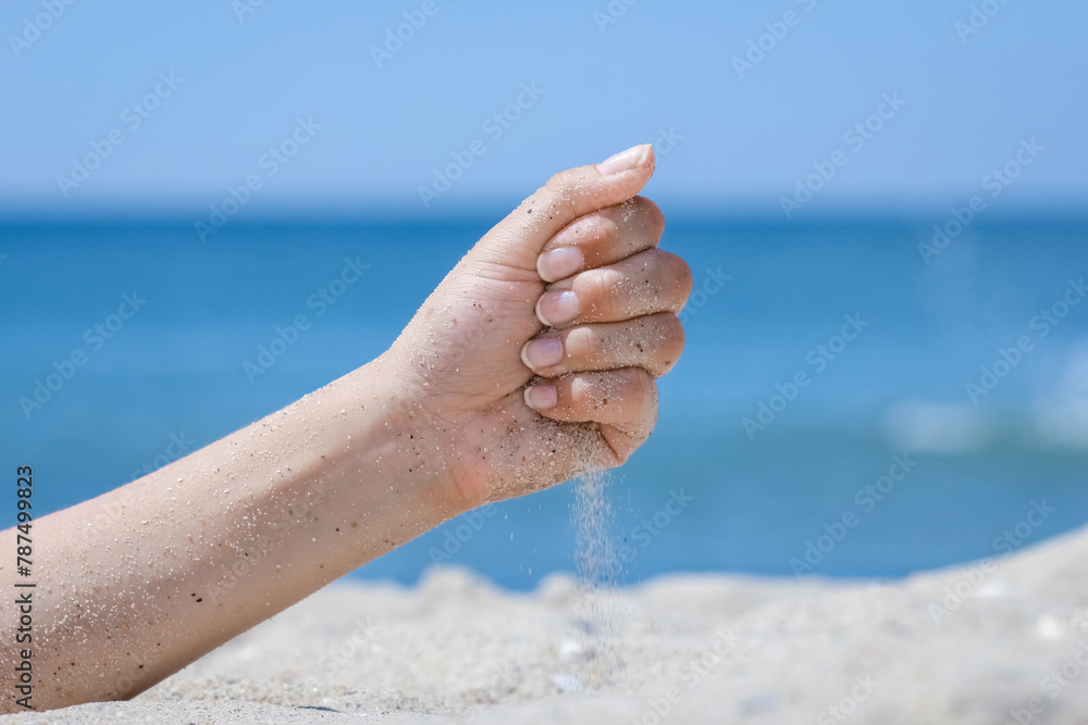 A Hands pour sand off the sea on nature on a journey. Vacations at sea sand time passes.