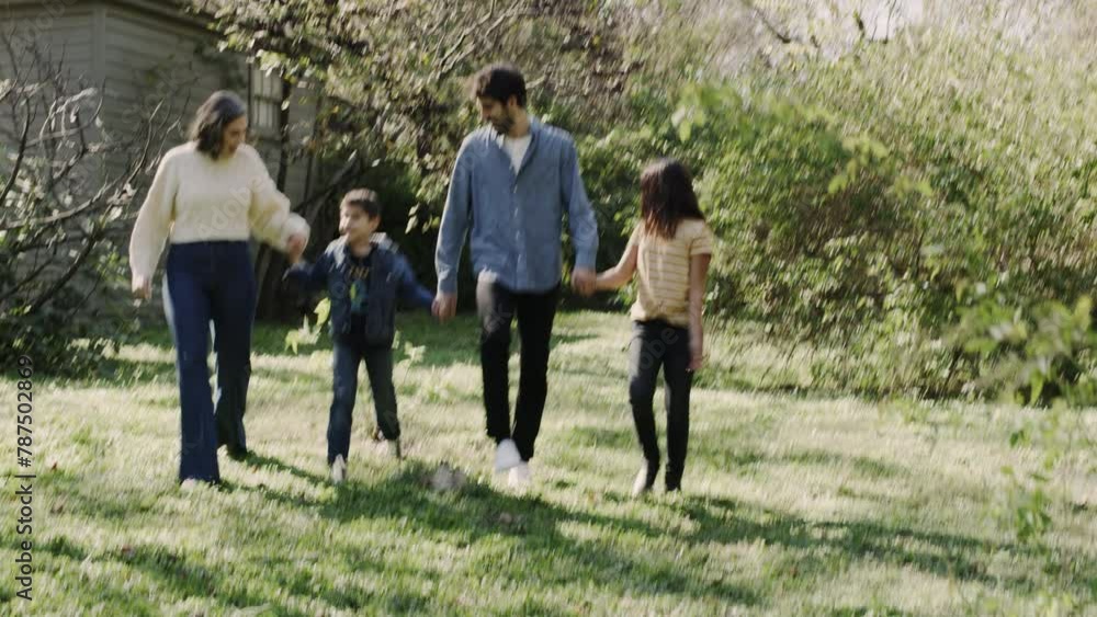 Mom and dad walk with their children outside near their home Mom and dad walk with their children outside near their home