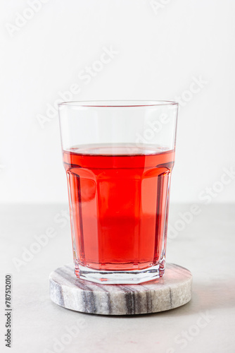 Red berries and fruits drink in the glass on the light background.