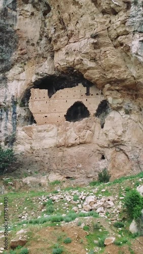 Drone footage showcases historical ruins of ancient Christian three story rock church dating back to 7th century Eastern Roman Empire. The view highlights architectural remnants and cultural heritage photo